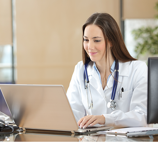 Person smiling while looking at a laptop